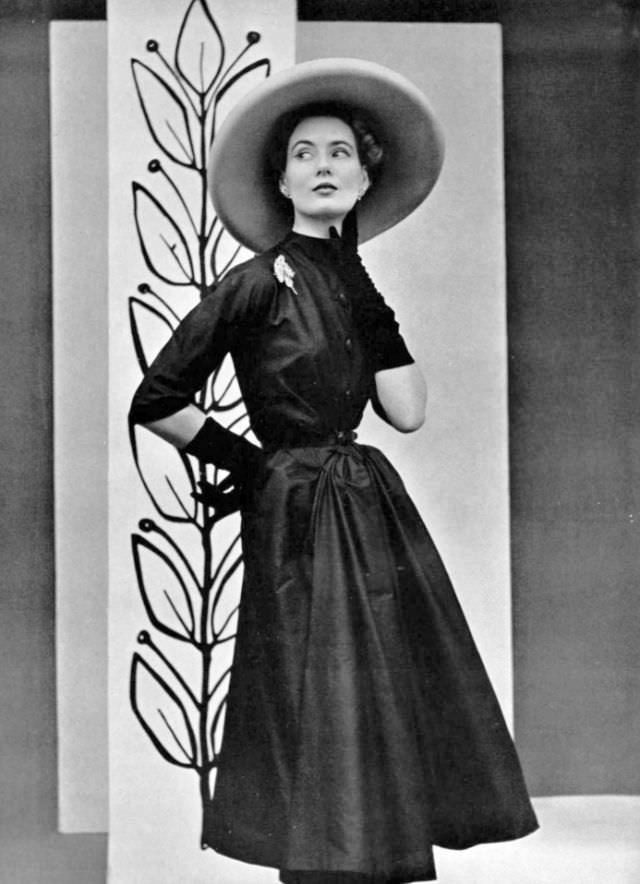 Pat O'Reilly in a black raw silk afternoon dress by Madeleine de Rauch, L'Officiel, 1952.