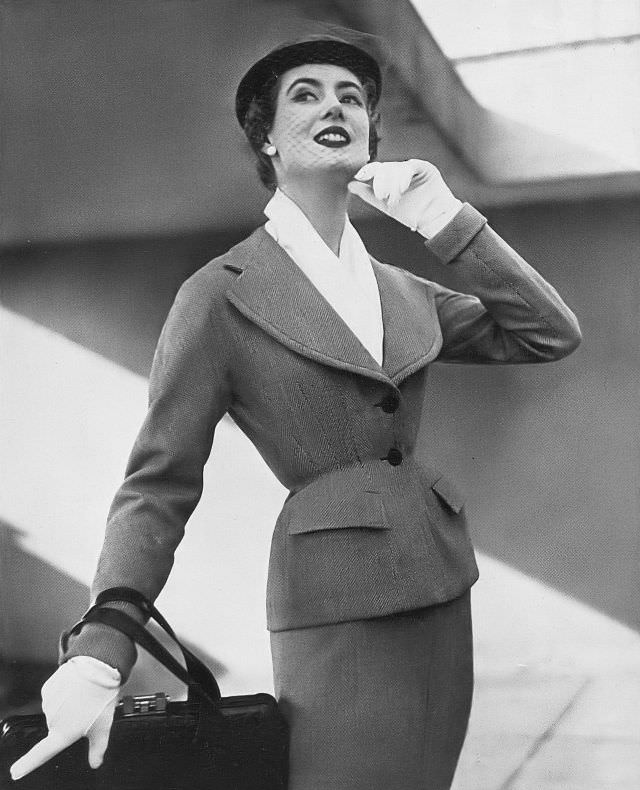 Pat O'Reilly in a gray-and-white birdseye suit by Lachasse, Harper's Bazaar UK, March 1952.