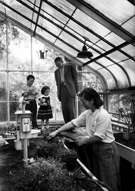 Katherine Oppenheimer and her children Peter and Toni in their home greenhouse, 1949.