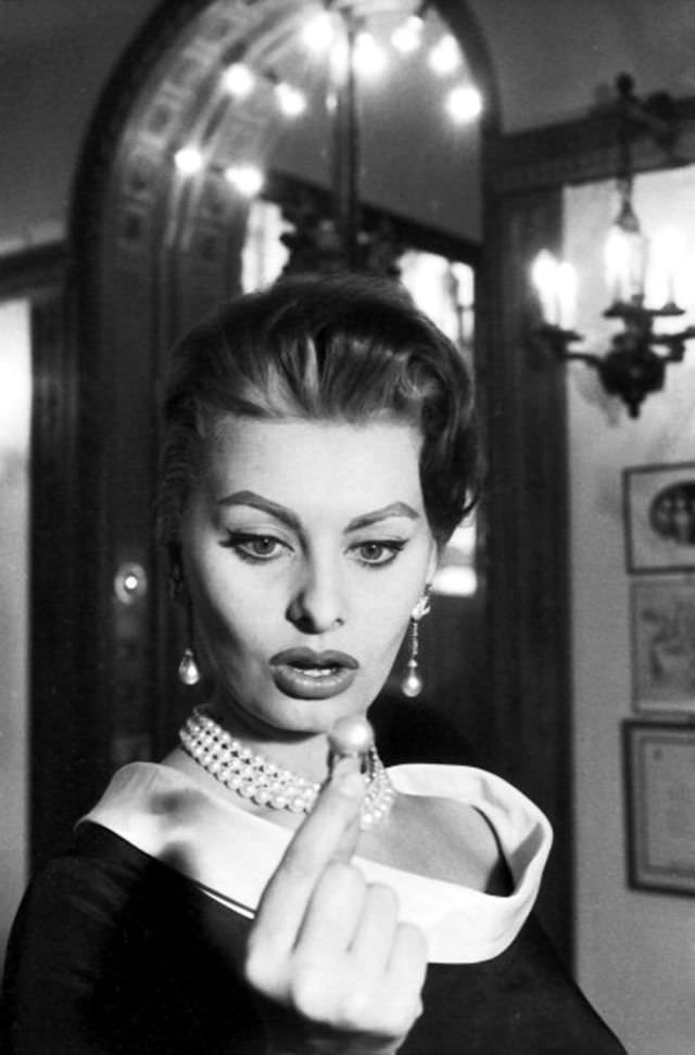 Sophia Loren admiring a pearl ring at Cartier in Paris, given a bronze Eiffel tower, 1956.