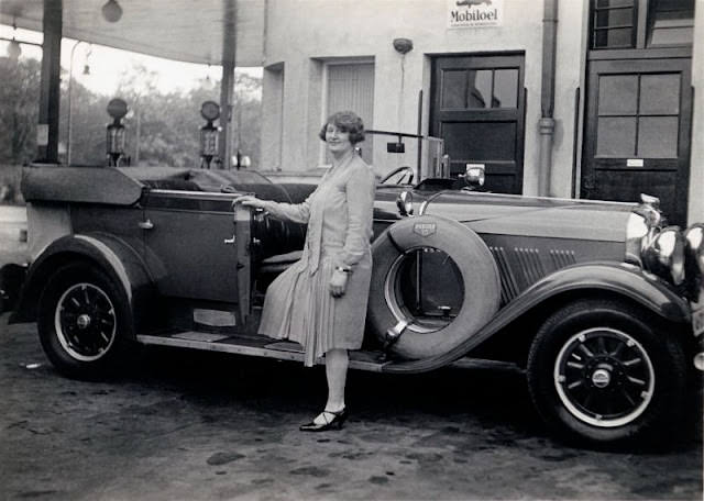 Fashionable lady with a 1928 Auburn 8-115 Phaeton Sedan at a petrol station in Germany, circa 1928.