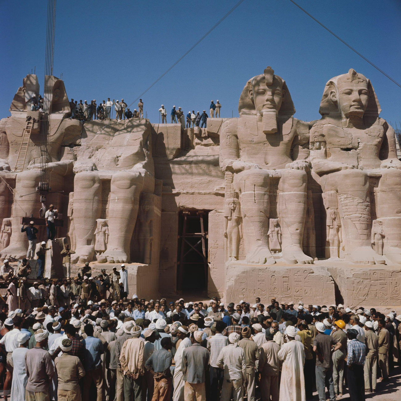 Workers in front of Pharaoh Ramesses II's statues at Abu Simbel during the 1967 reassembly after relocation to avoid Nile flooding from the Aswan High Dam.