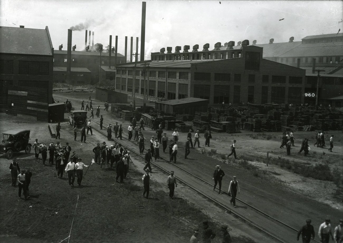 Buckeye Steel yard with workers, cars, and railroad track, founded October 1902, located on Parsons Avenue, merged with Worthington Industries in 1980, circa 1920s