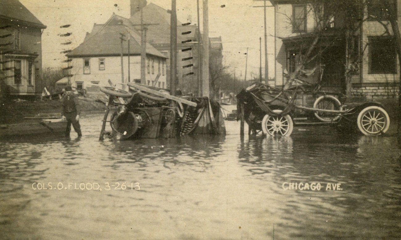 Chicago Avenue during the 1913 flood, with overturned car and boat, 1913.