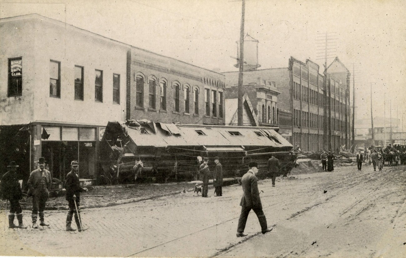 Broad and Belle Streets during the 1913 flood, featuring an overturned streetcar, March 27, 1913.