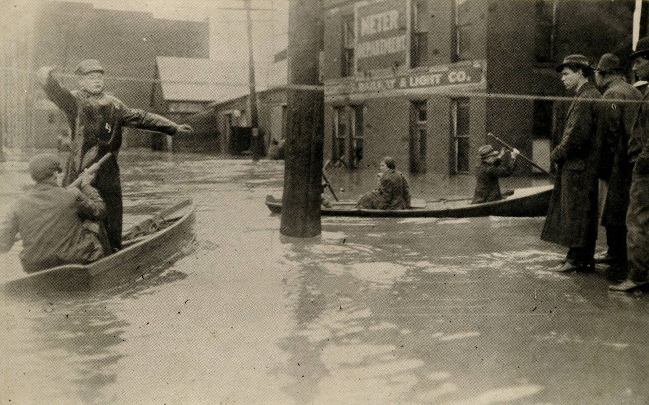 Broad and Levee Streets during the 1913 flood, showing people and rescue boats, March 26, 1913.