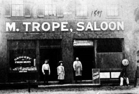 Exterior view of Mendel Trope's grocery store and John Baltz and Charles Amend's saloon, 1909.