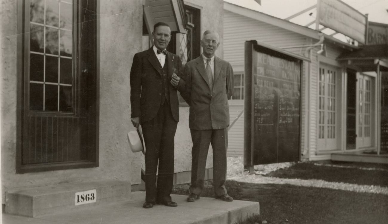 Harry Edward Markins and William Riley Barnett outside Barnett Realty office on Sullivant Avenue, 1940s