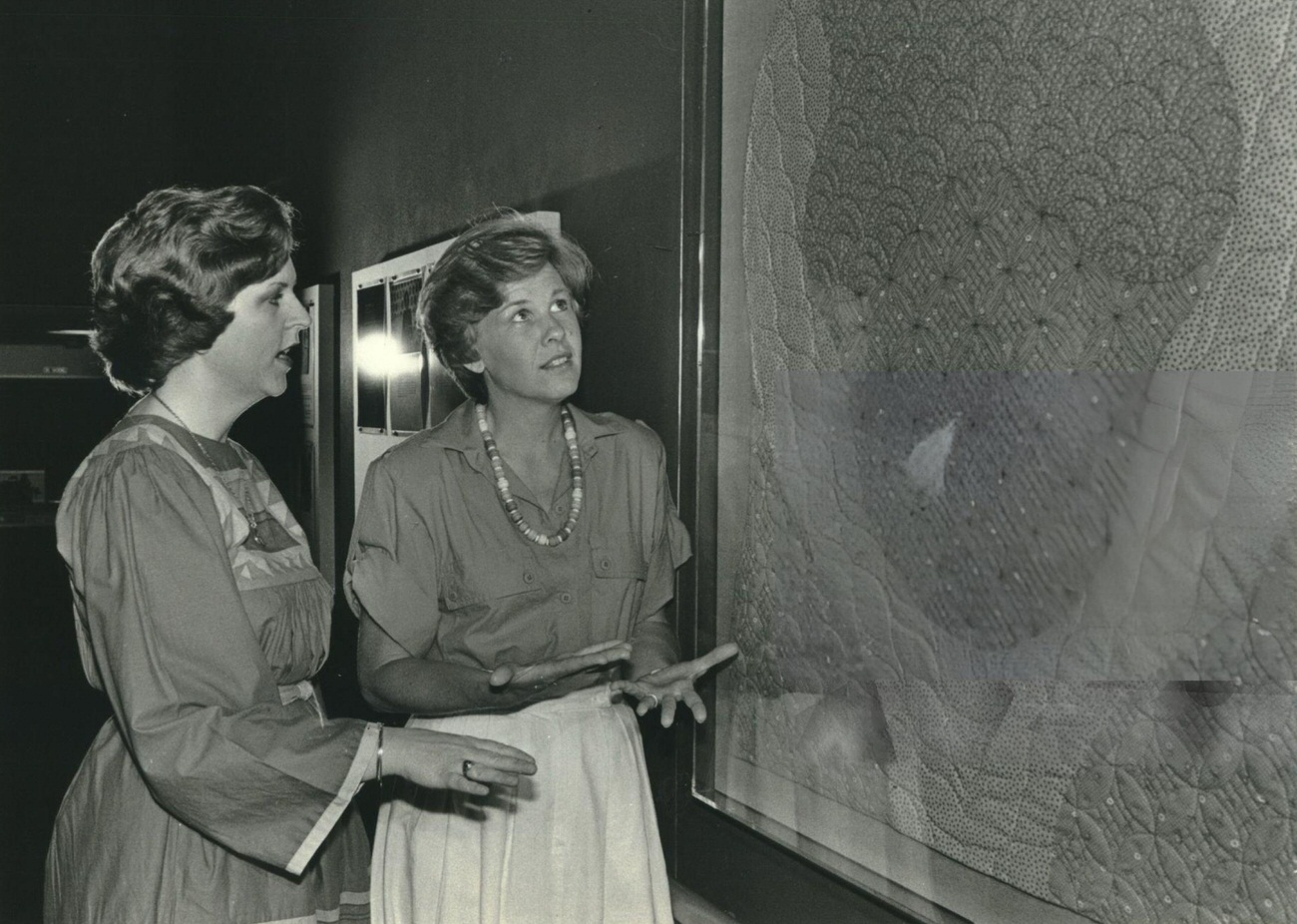 Jane Thompson admires Carol Strittmatter's "The Calico Kitten" quilt at the YWCA Masterson Branch, part of "The Birth Project" by Judy Chicago, Houston, Texas.
