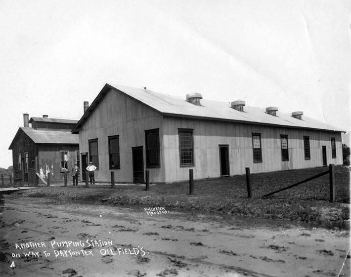 Two men in front of a pumping station, 1920s