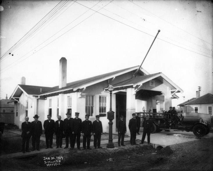 Men, including Houston firefighters, standing and sitting on a 1917 American La France Pumper, 1917.