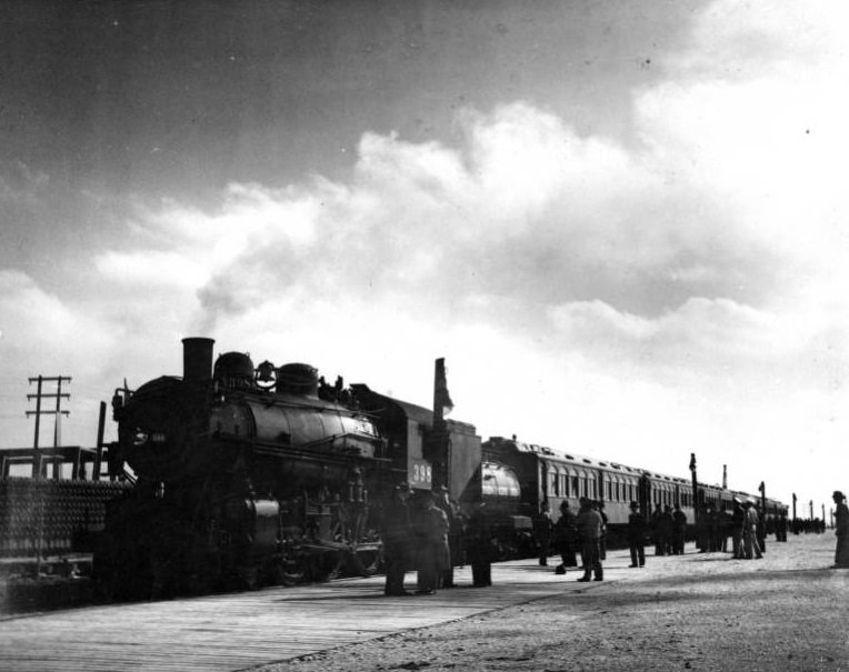 Steam engine train at a platform with people, 1940s.