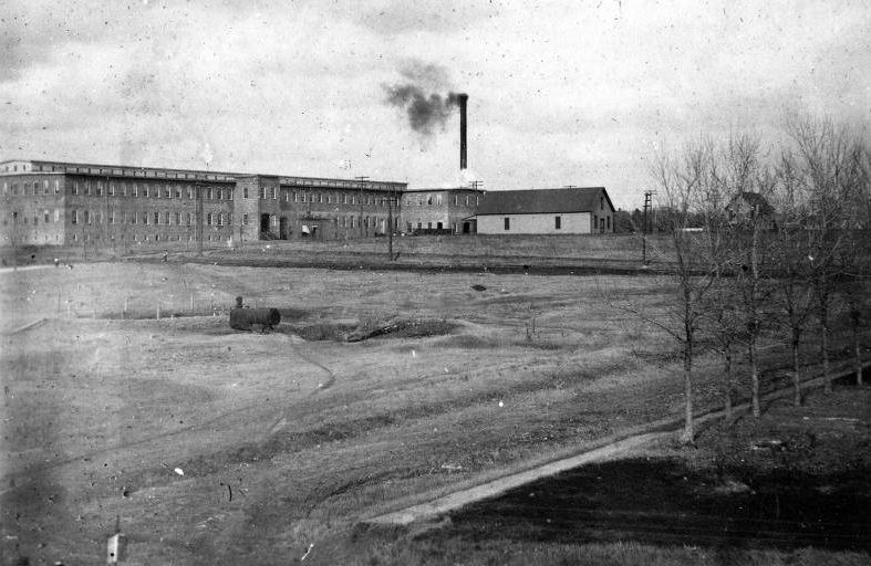 Cotton mills in Dallas with a fallow field in front, 1896.