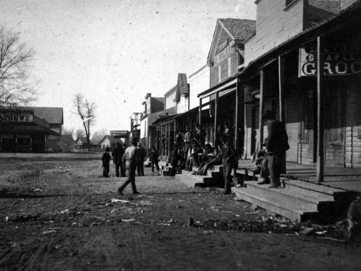 Men on store steps, street view, 1896