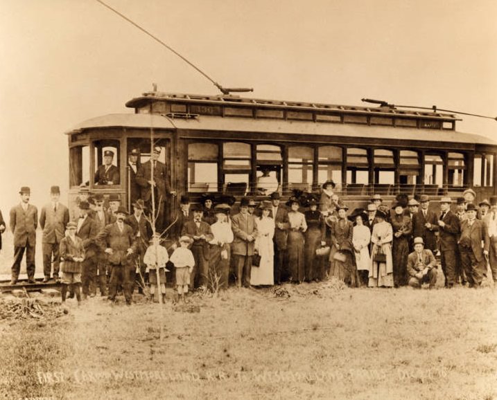 Large group on and around a trolley car, Westmoreland Farms, 1910.
