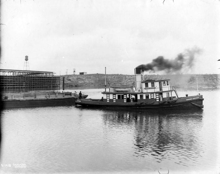 Tugboat pulling a barge, 1920s