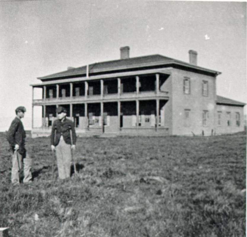 Two men standing outside the Presidio Hospital, 1867