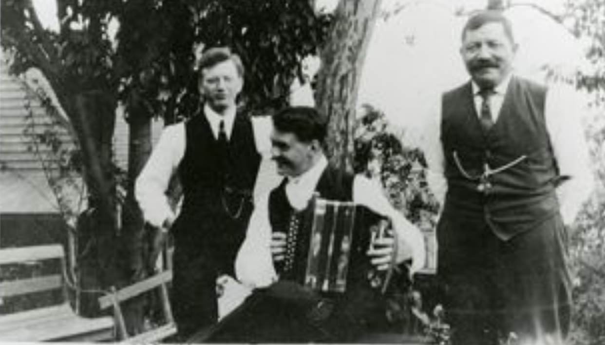 Portrait of Frank Schoenstein, an unknown person with accordion, and Mr. Imdorf, early 1900s