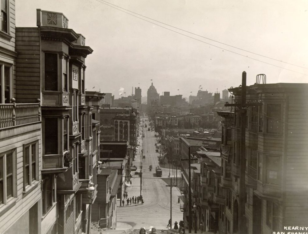 Group of children on Kearny, looking towards Market, uphill from Broadway, early 1900s