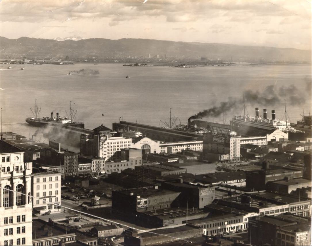 View across the Bay towards the east with piers 18 and 20 in the foreground, 1930