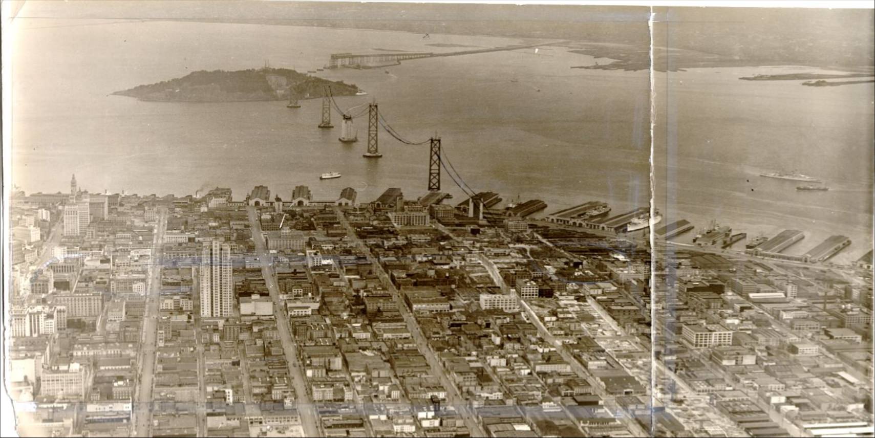 Aerial view of the waterfront and the Bay Bridge under construction, 1935
