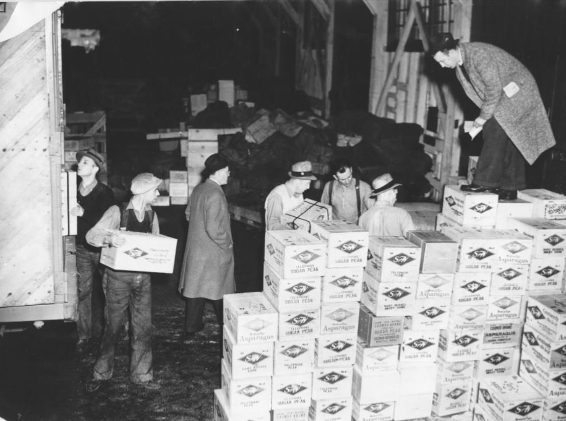 Men unloading boxes from a truck, 1938