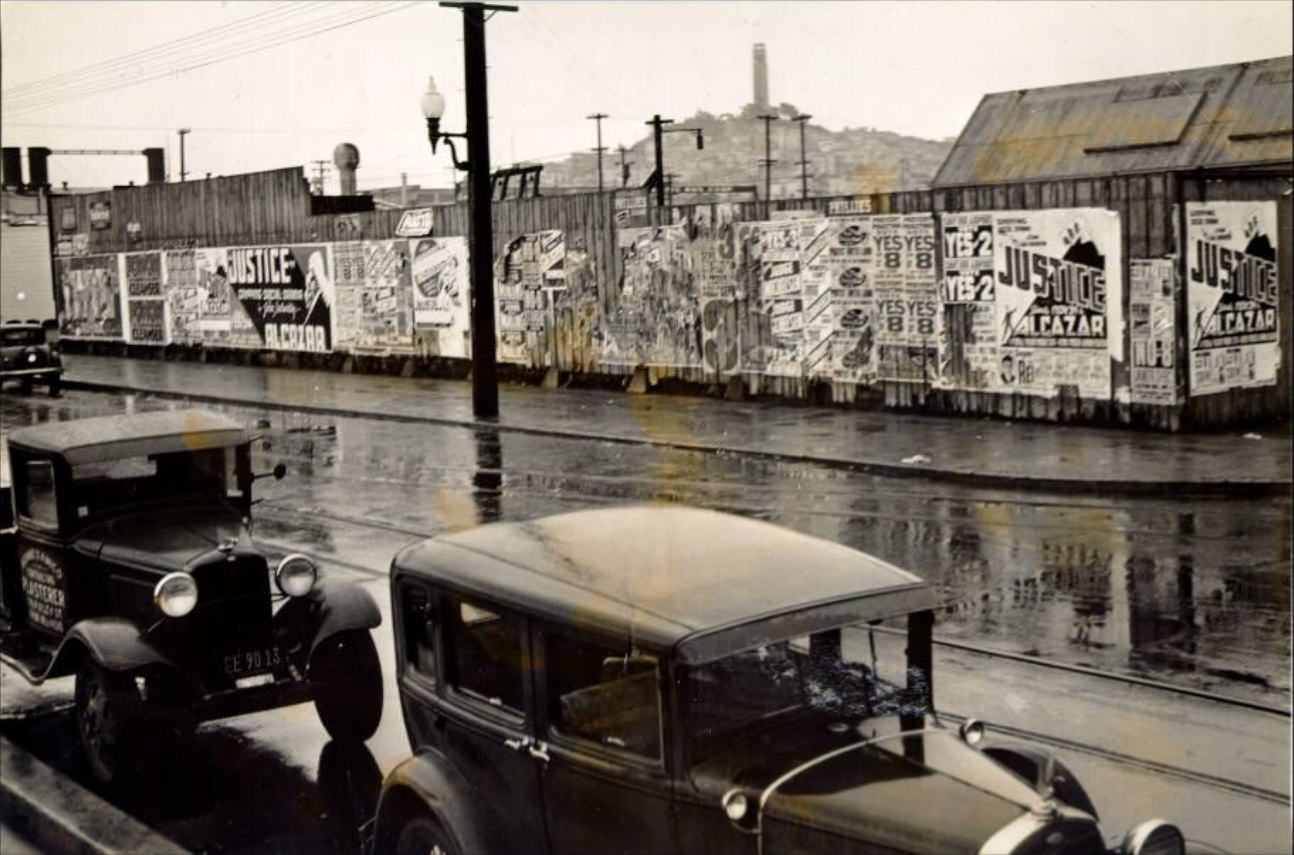 Fence covered with posters at Fisherman's Wharf, 1937