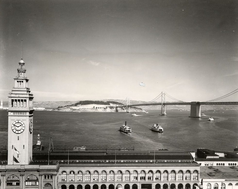 View of Ferry Building with Yerba Buena Island and nearly completed Bay Bridge in the background, 1937