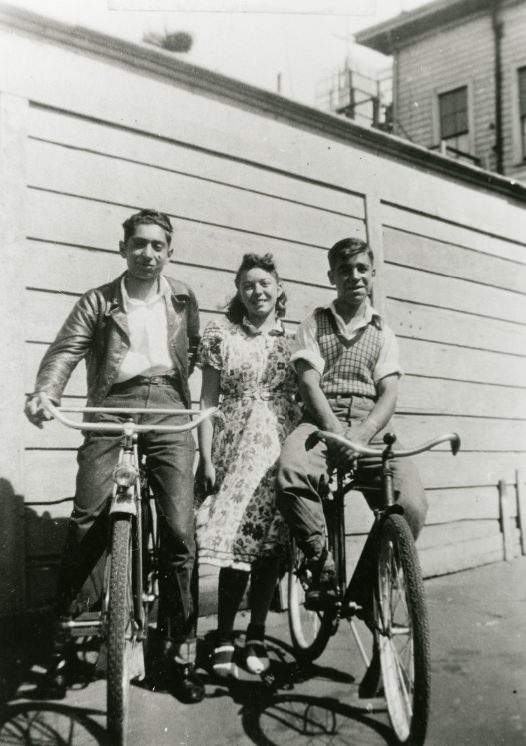 Ahi and Jesse on bicycles and Sally on Scott Street, 1939