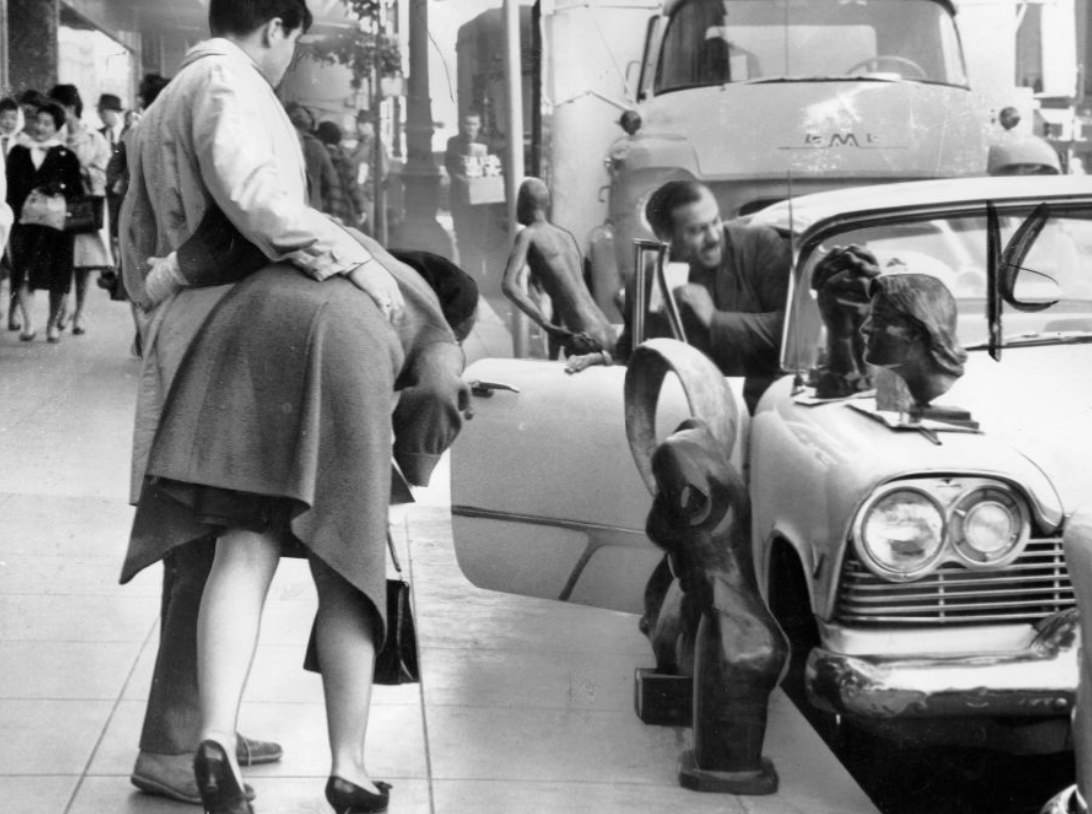 Artist Elliott Moorez displaying sculptures on Geary Street, 1962.