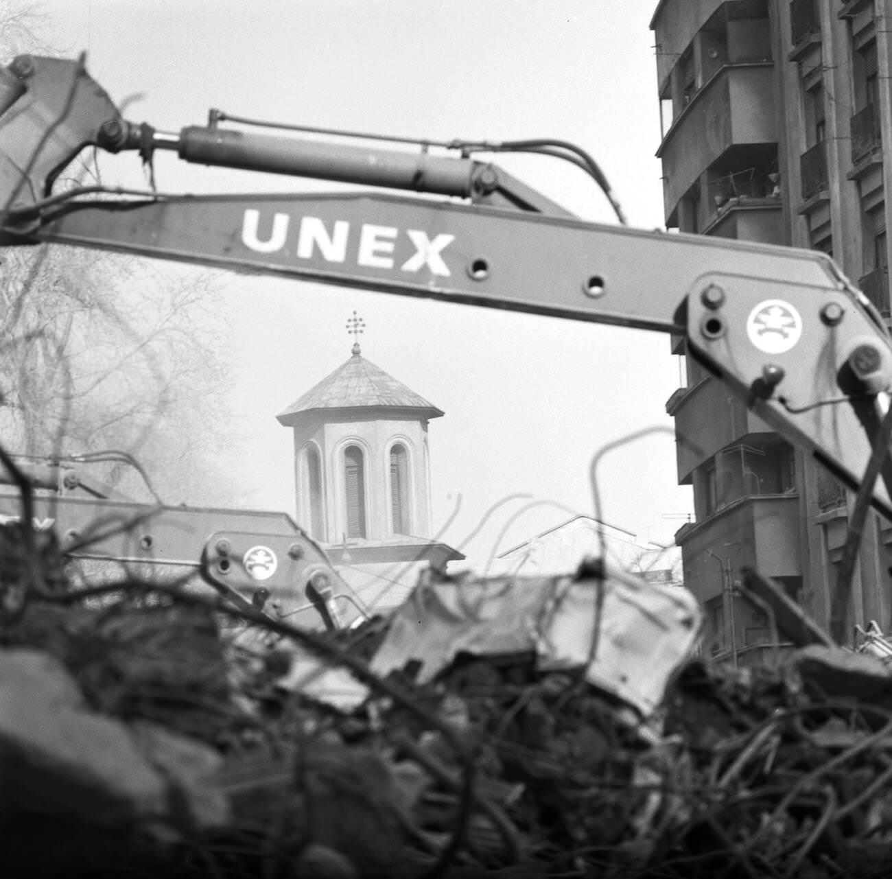 Church tower seen through the arm of a machine cleaning up rubble after the deadly earthquake in Bucharest, Romania, March 1977.