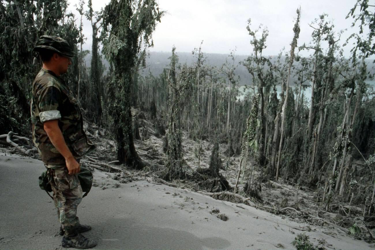 A sailor surveys damage at Naval Station Subic Bay, Luzon, Philippines, caused by volcanic ash from Mount Pinatubo's eruption.