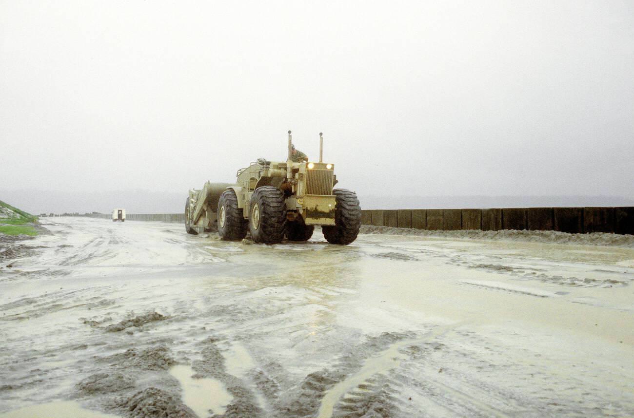 A Seabee clearing volcanic ash and mud from a road at Naval Air Station Cubi Point