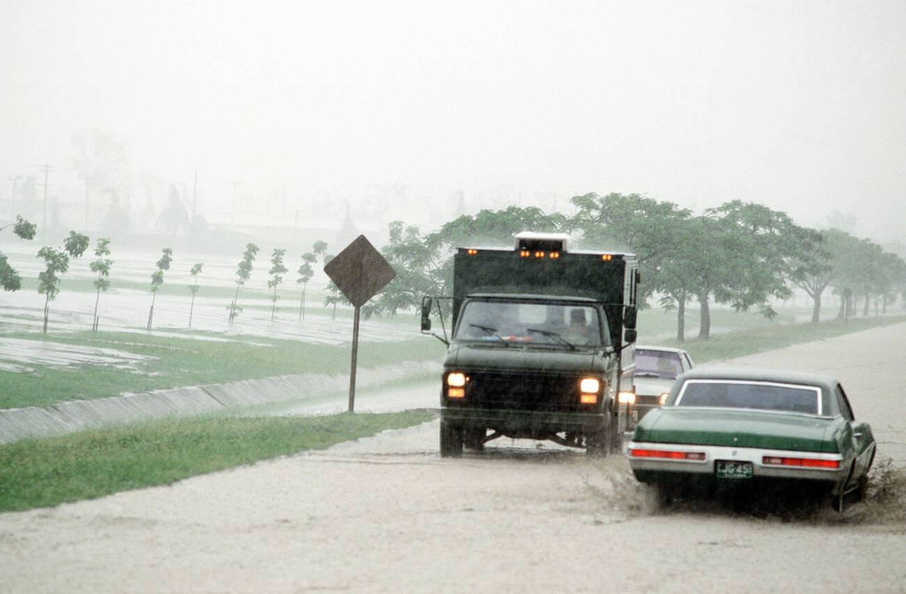 Vehicles navigate a flooded road at Clark Air Base, Luzon