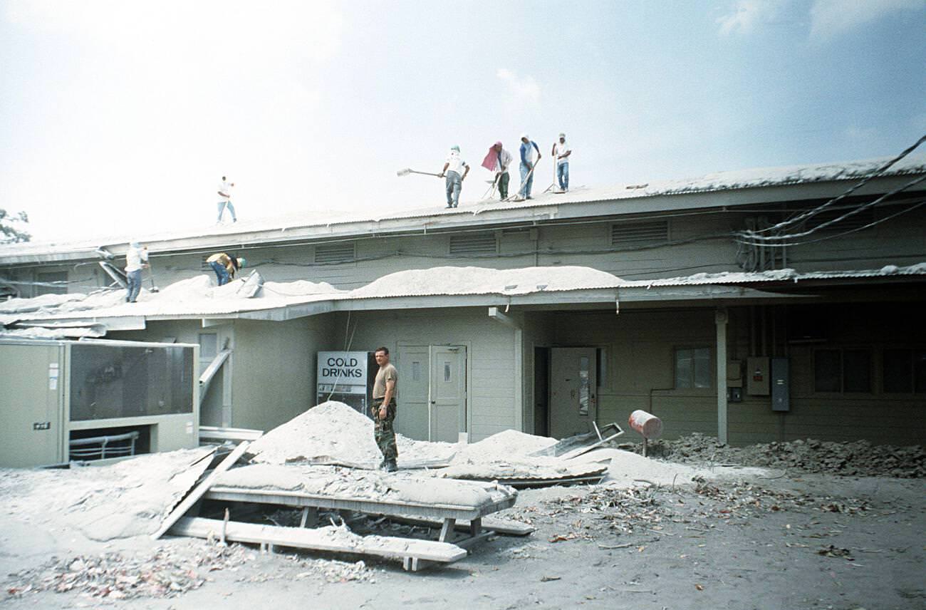 Airmen and Filipino workers clearing volcanic ash from a roof at Clark Air Base, Luzon, Philippines, after Mount Pinatubo's eruption.