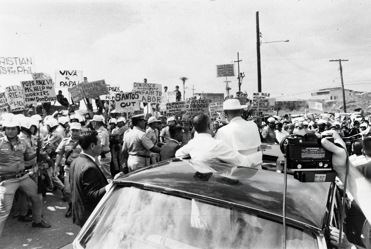 Riot police maintain order during Pope Paul VI's visit amidst protests and security concerns, with Cardinal Santos being a controversial figure.