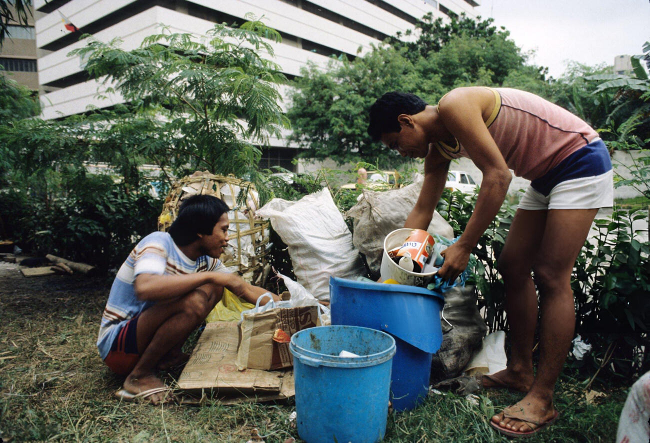 People scavenge garbage near Roxas Boulevard amidst mass demonstrations of the People Power Revolution in Metro Manila, 3rd March 1986.