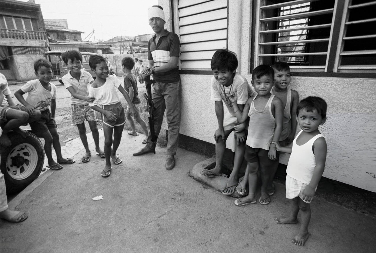 Children with a 'Vigilantes' anti-communist militia member in Manila, Philippines, December 1987.
