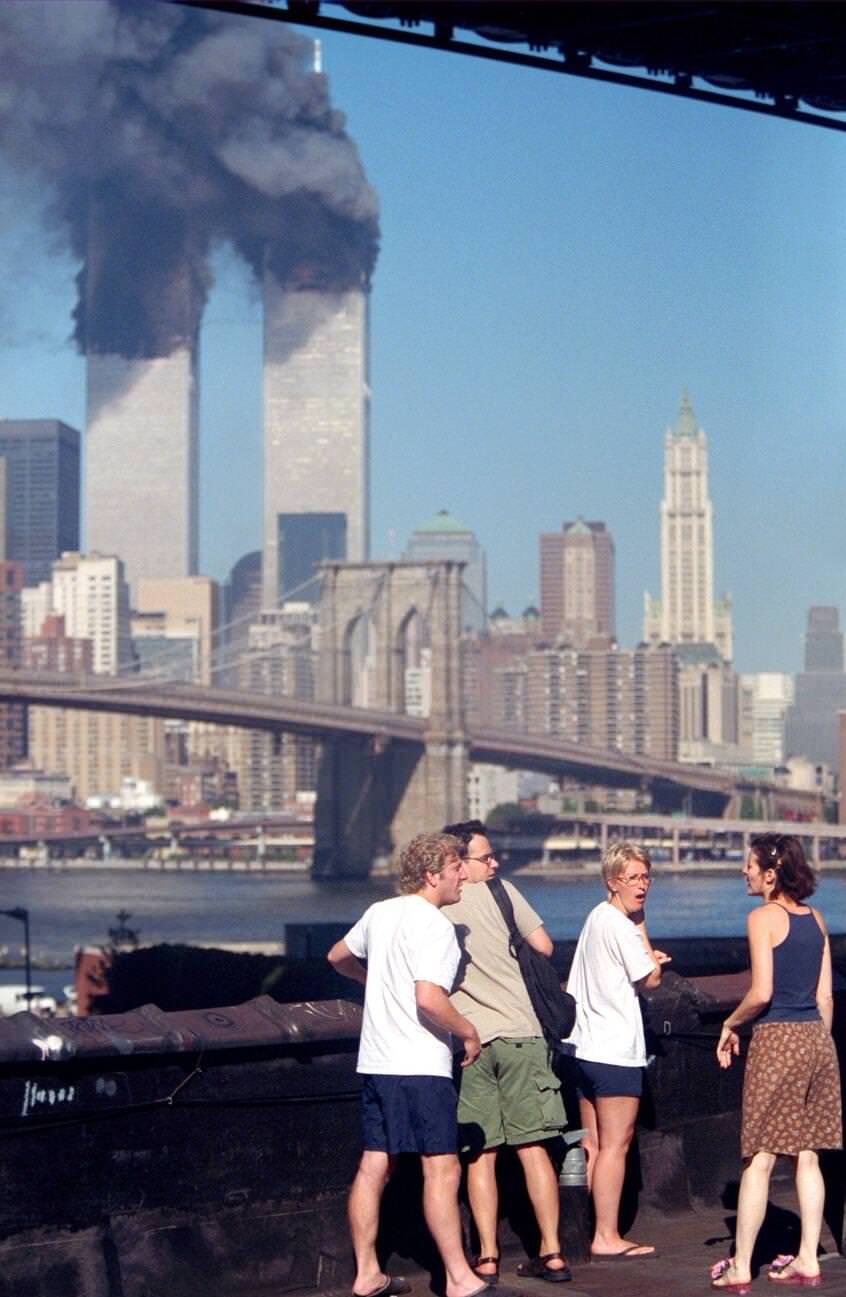 Residents on the rooftop of an apartment building in Brooklyn watching the Twin Towers burn.