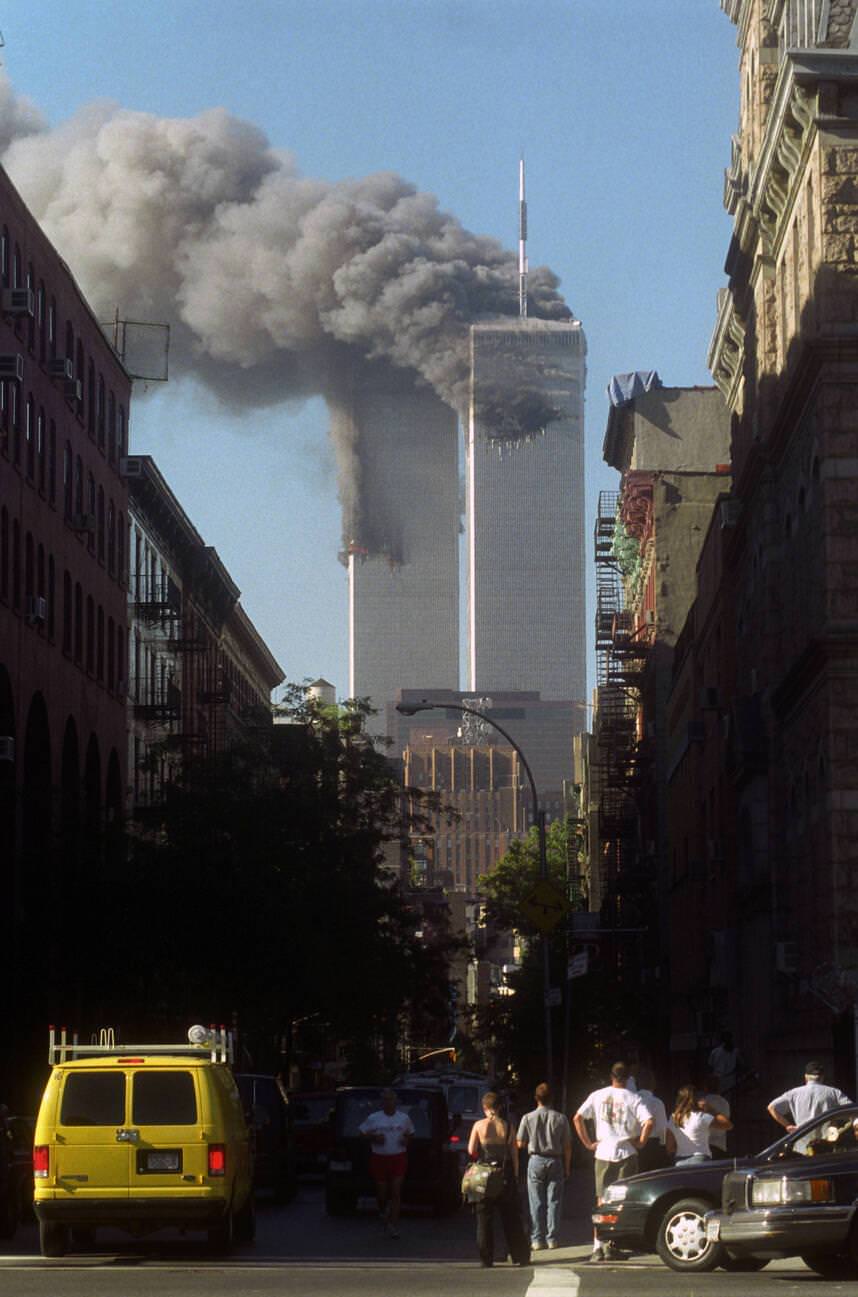 Crowds on West Broadway view the twin towers of the World Trade Center on the morning of September 11th 2001