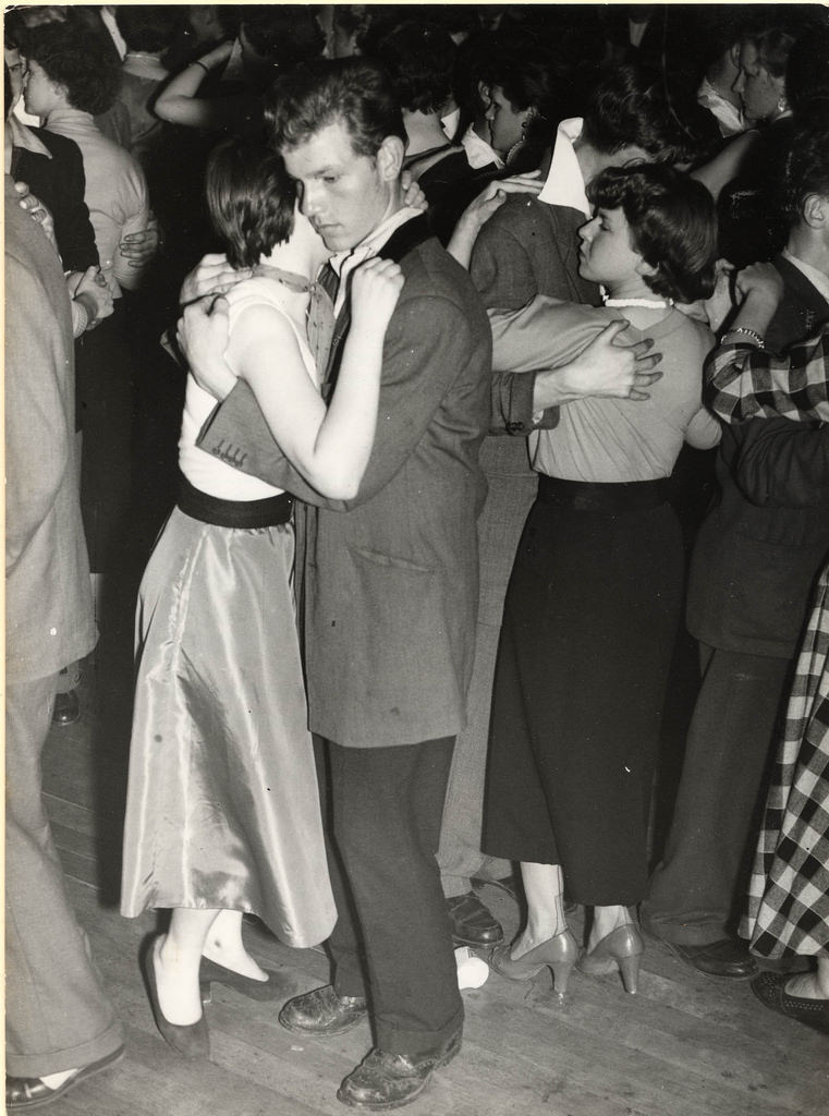 A Teddy Boy with his girl ‘Moon Dance’ at a Dance Hall – July 1955 – note the Drape Jacket with half back full velvet collar with 16-17″ turned up trousers and Brogue Shoes.