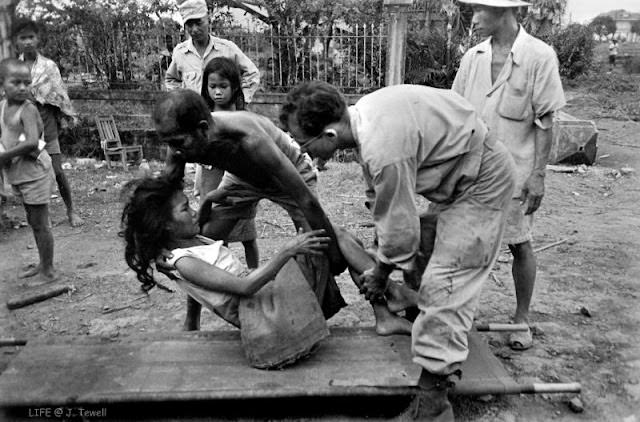 Injured Filipino woman being help by American soldiers, Manila, Philippines, February 1945