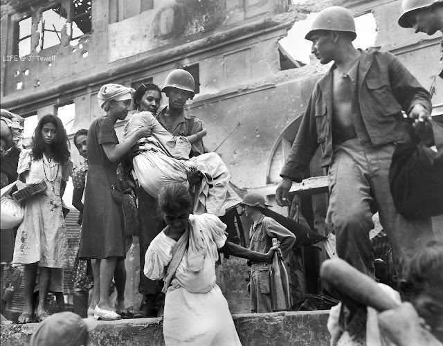 Intramuros, Manila, Philippines March 1945. Filipino survivors from the Santa Clara Monastery being rescued by American soldiers right after being liberated from the Japanese.