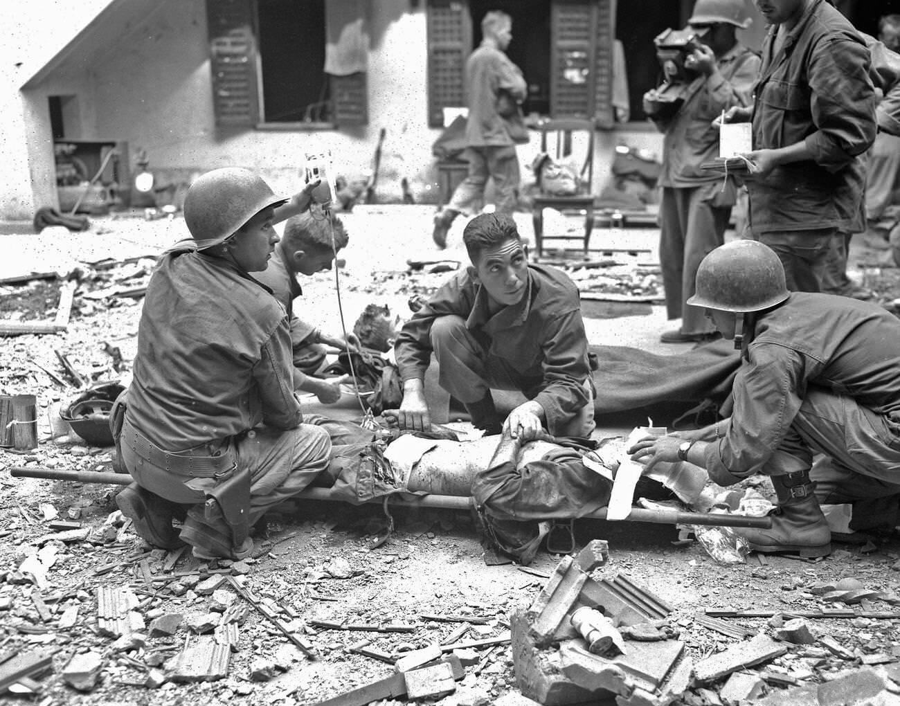 Medics with the 37th Infantry Division administer plasma to a wounded soldier amid the Battle of Intramuros, 1945.