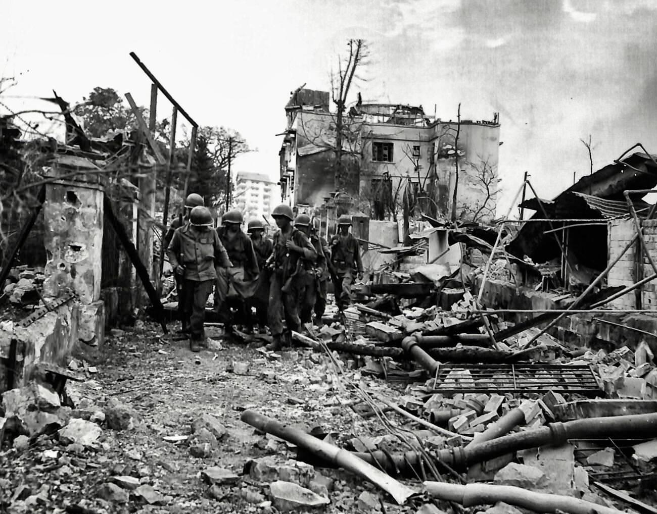 Troops from the 5th Troop, 1st Cavalry, advance cautiously down Taft Avenue in Manila, Philippines, 1945.