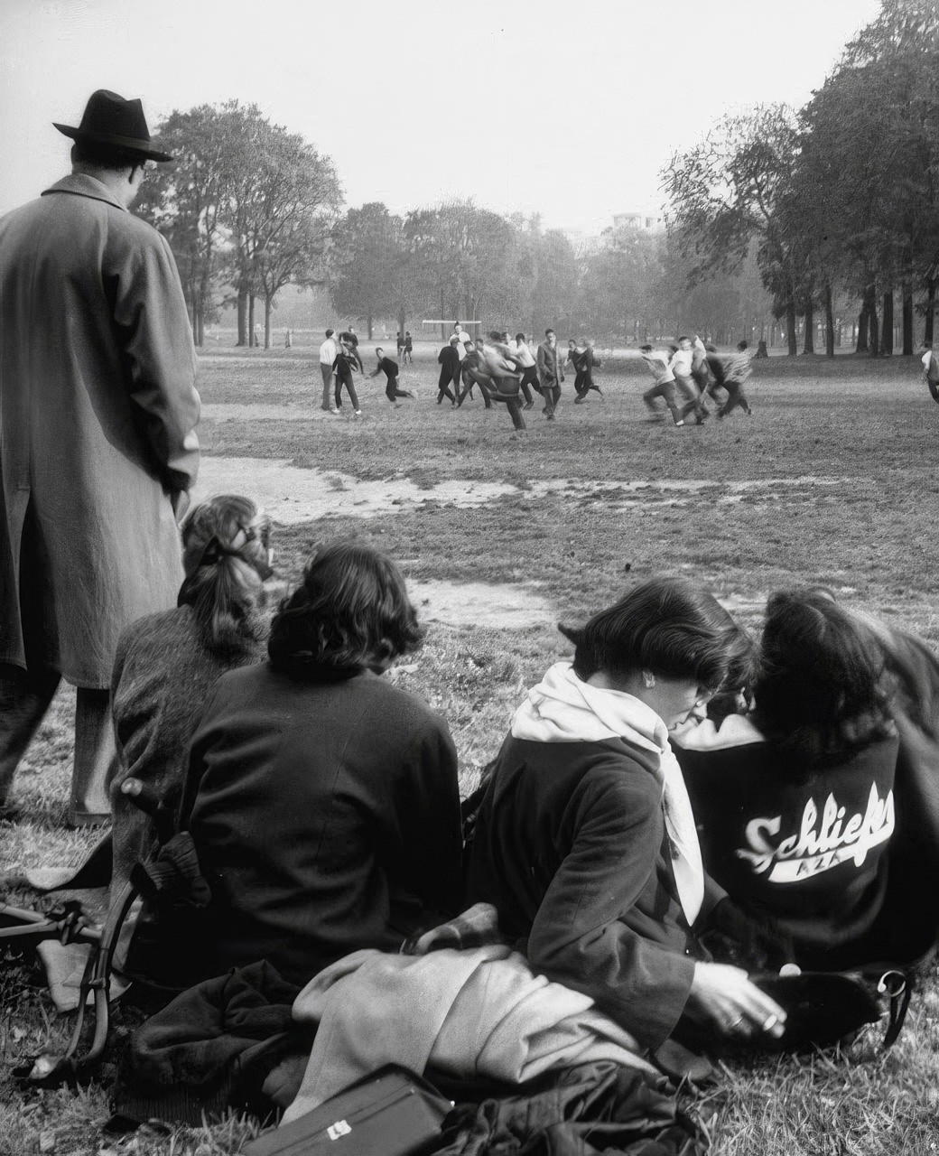 In the Bois de Boulogne, a Saturday afternoon football game is watched by girls and a father (left). Occasionally a few French boys join in the game.