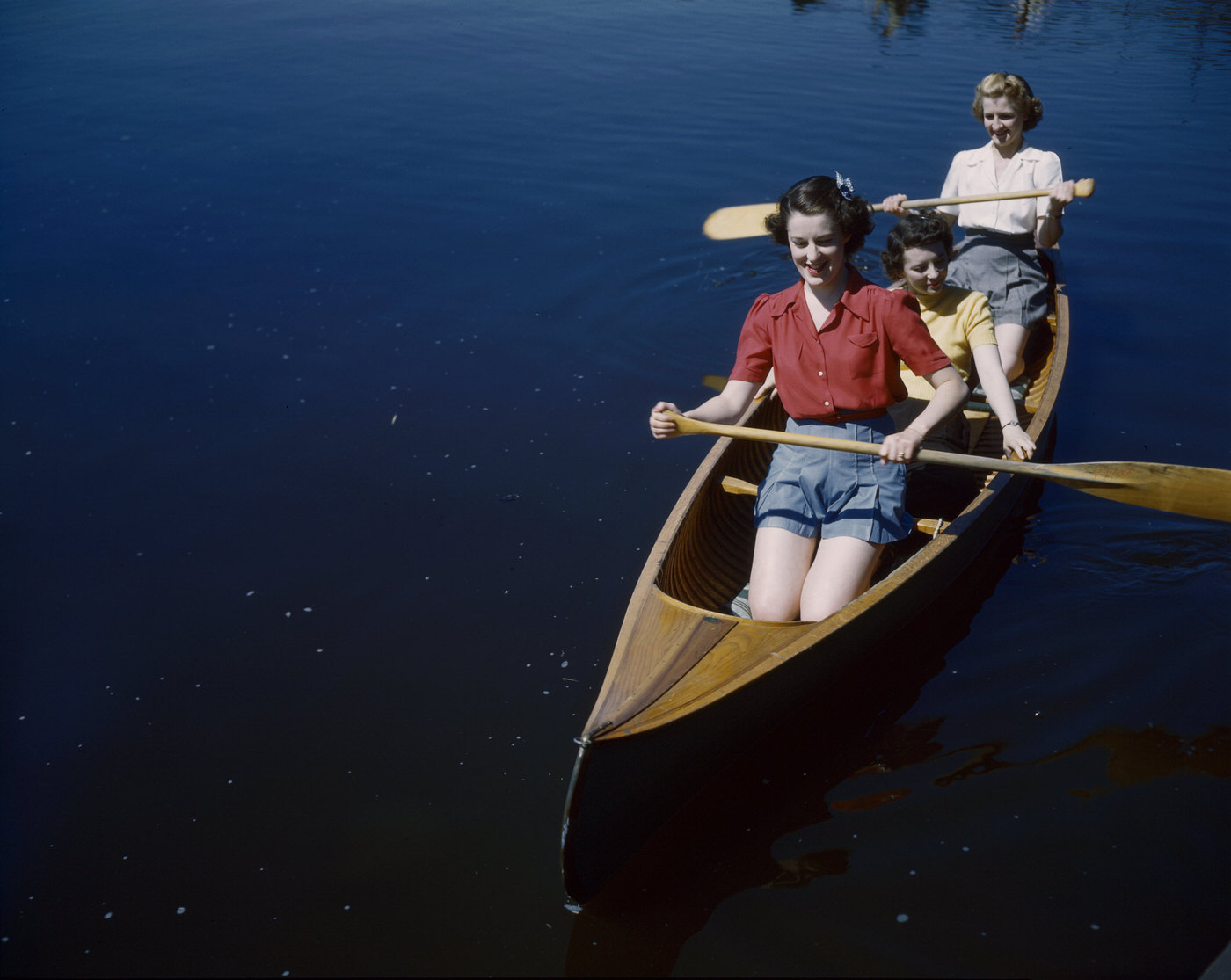 Three women in the Canadian Army paddling a canoe, Canada