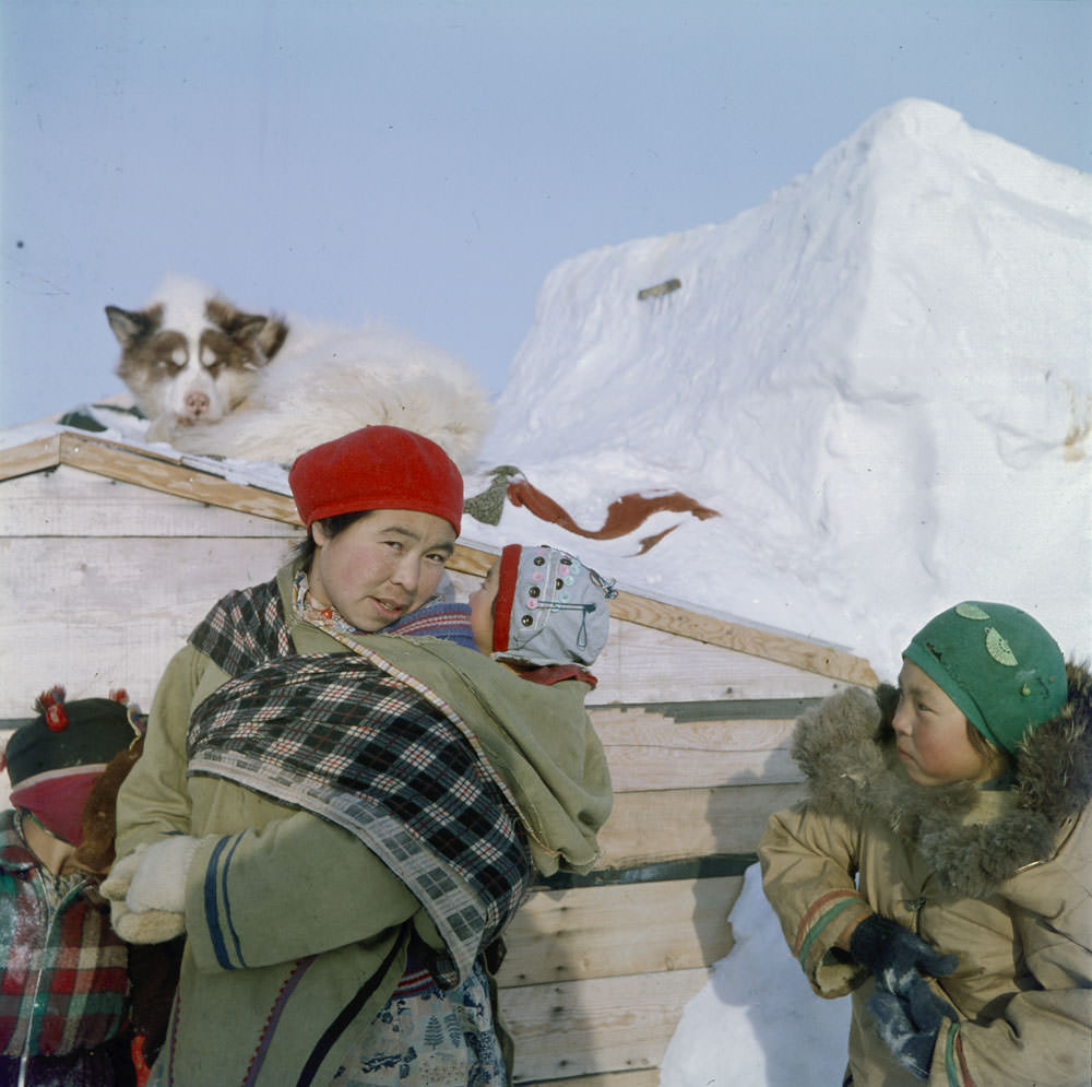 Woman and three children outside in winter clothes, May 1956