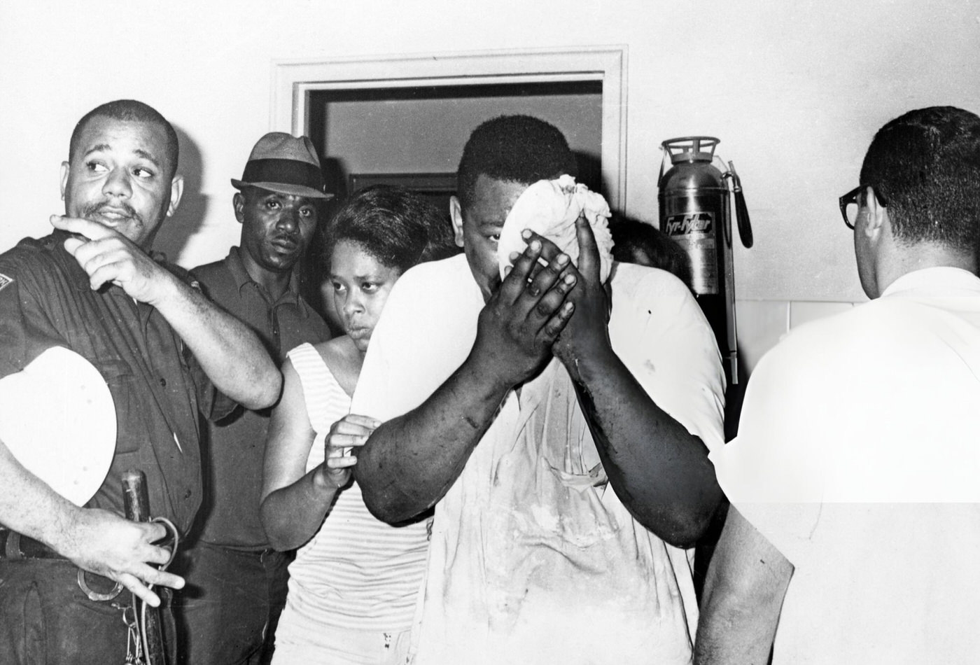 A Newark man holds his injured eye as he is admitted to hospital during the riots taking place in