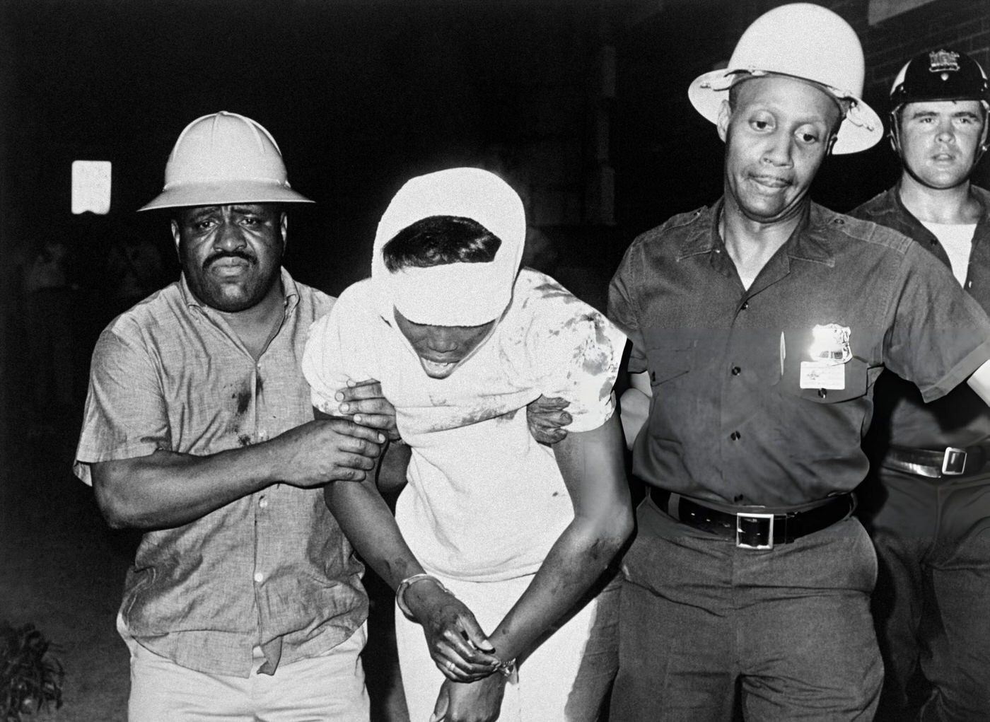 Helmeted police riot guards drag a wounded rioter away from the scene of violence